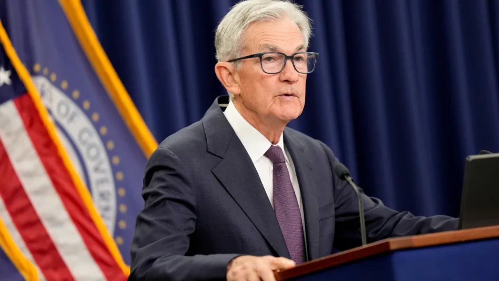 Jerome Powell speaking at a podium during a Federal Reserve press conference reviewing monetary‑policy outlook.